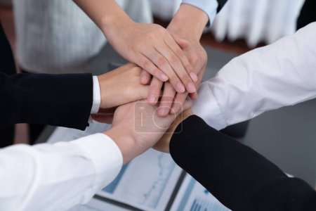 Foto de Top view closeup business team of suit-clad businesspeople join hand stack together. Colleague collaborate and work together to promote harmony and teamwork concept in office workplace. - Imagen libre de derechos