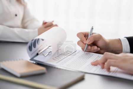 Un homme d'affaires proche signe un contrat ou un document juridique avec un stylo à la main lors d'une réunion d'entreprise pour un accord commercial ou une décision exécutive juridique de rembourser un prêt ou de déclarer faillite. Solde budgétaire