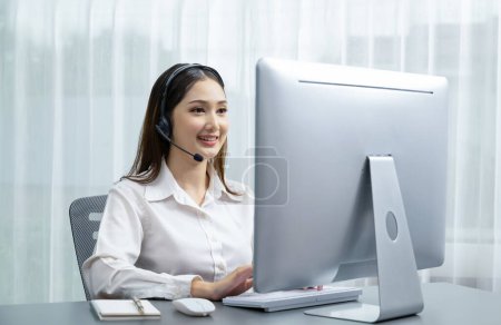 Asiatisches Callcenter mit Headset und Mikrofon an ihrem Laptop. Betreiberinnen bieten einen außergewöhnlichen Kundenservice. Supportive Call Center Agent hilft Kunden auf Anfrage. Enthusiastisch