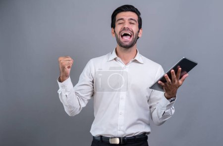 Photo for Confident businessman in formal suit holding tablet with surprise look for promotion or advertising. Facial expression and gestures indicate excitement and amazement on an isolated background. Fervent - Royalty Free Image