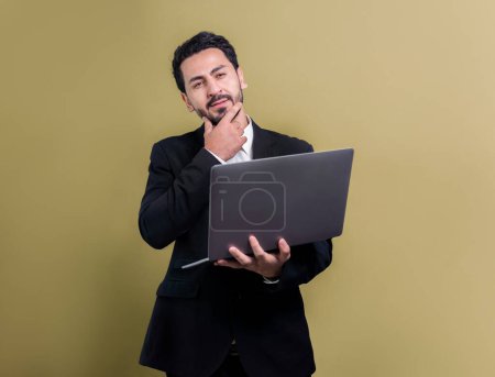 Photo for Successful businessman in black suit with innovative tech concept, standing pose and holding laptop and smiling with excitement on copyspace background for promotion or advertisement. Fervent - Royalty Free Image