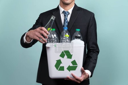 Photo for Businessman hold recycle bin filled with plastic bottle on isolated background. Corporate responsibility for green environment and community. Waste separation and management concept. Alter - Royalty Free Image