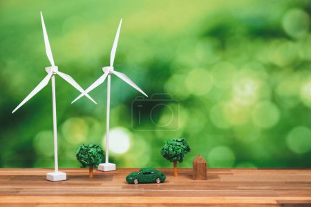 Green eco car und Windrad Turbine Modell mit Park on office table design. Nachhaltige und erneuerbare saubere Lösung mit null CO2-Emissionen für grüne Ökologie und Umweltkonzept. Alter