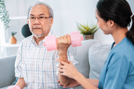 Photo for Unyielding senior patient doing physical therapy with the help of his caregiver. Senior physical therapy, physiotherapy treatment, nursing home for the elderly - Royalty Free Image