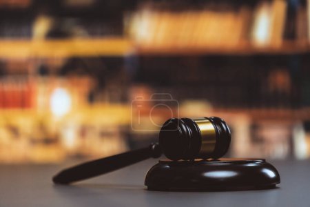 Schwarze hölzerne Hammer auf Kanzlei oder Anwaltskanzlei Hintergrund als Justiz und das Rechtssystem für Anwalt und Richter, symbolisieren Autorität und Fairness in Verfahren und Versteigerungen. Gleichgewicht