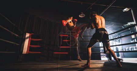 Photo for Asian and Caucasian Muay Thai boxer unleash knee attack in fierce boxing training session, delivering knee strike to sparring trainer, showcasing Muay Thai boxing technique and skill. Spur - Royalty Free Image