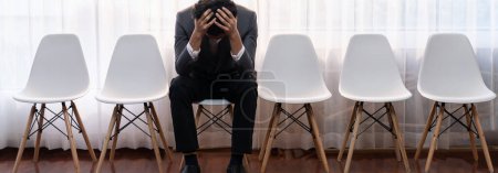 Photo for Nervous and panic job applicant with stressful emotion on job interview while he sitting and waiting for his turn. Sad businessman holding his head with hands after making mistake. Trailblazing - Royalty Free Image