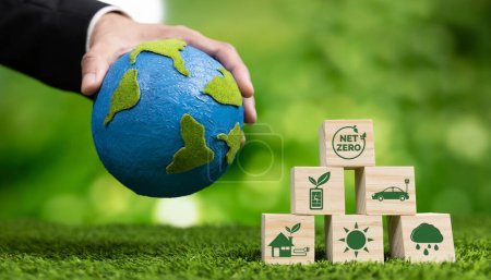 Businessman hand with paper globe and net zero symbol cube for eco awareness. Ethical company reduce CO2 emission, fight climate change and global warming by clean energy for green environment. Alter