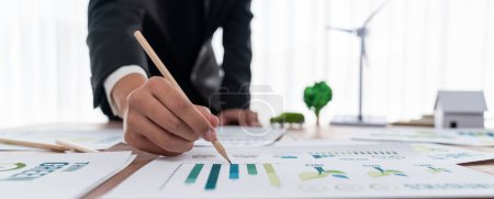 Photo for Businessman planning for green business strategy in office with paper documents focused on eco-friendly and energy sustainable policy to reduce CO2 emission for green environment. Trailblazing - Royalty Free Image