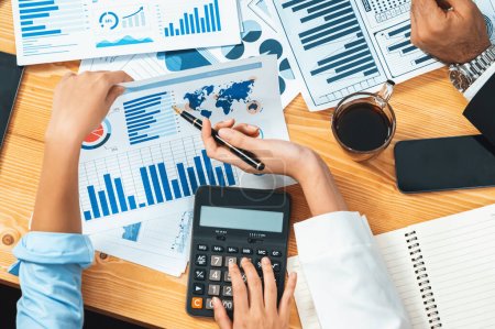 Photo for Corporate budget, executive utilize cutting-edge business intelligence financial data dashboard paper on meeting table. Accountant or auditor team examine and calculate income and expense. Meticulous - Royalty Free Image
