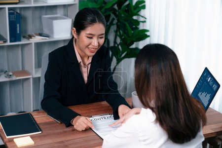 Photo for Business deal meeting, young businesswomen carefully reviewing terms and condition of contract agreement papers in office. Corporate lawyer give consultation on contract deal. Enthusiastic - Royalty Free Image