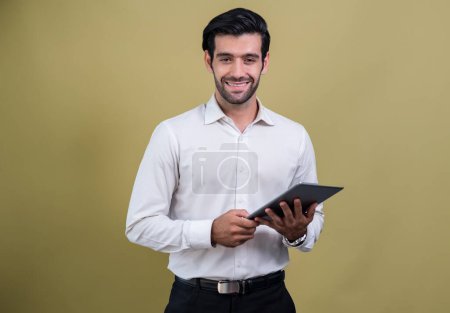 Photo for Confident businessman in formal suit holding tablet with surprise look for promotion or advertising. Facial expression and gestures indicate excitement and amazement on an isolated background. Fervent - Royalty Free Image