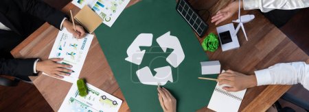 Top view business people planning and discussing on recycle reduce reuse policy symbol in office meeting room. Green business company with eco-friendly waste management regulation concept.Trailblazing