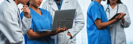 Photo for Medical staff team with doctor nurse and healthcare specialist professions working together with laptop and tablet in hospital. Medical workplace and healthcare community in panoramic banner. Neoteric - Royalty Free Image