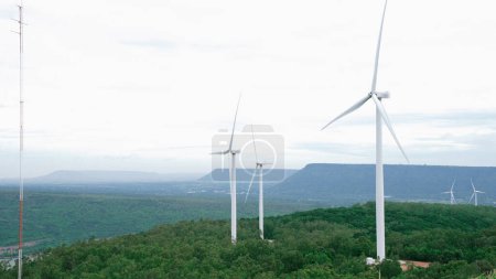 Photo for Progressive way of utilizing wind as renewable source of energy to power the modern way of life by wind turbine farm on green field or hill. Windmill generator generate electric with no CO2 emission. - Royalty Free Image