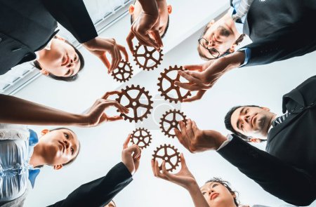 Below view group of multiracial business people joining gear wheels together as effective unity and productive teamwork concept. Efficient system business team process for solution solving. Habiliment