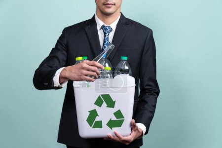Photo for Businessman hold recycle bin filled with plastic bottle on isolated background. Corporate responsibility for green environment and community. Waste separation and management concept. Alter - Royalty Free Image