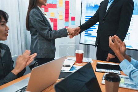 Photo for Diverse coworker celebrate with handshake and teamwork in corporate workplace. Happy business people united by handshaking after successful meeting or business presentation on data analysis. Concord - Royalty Free Image