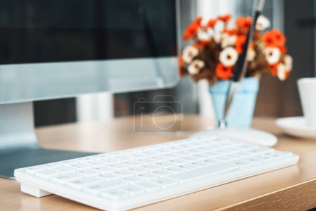 Foto de Cierre la computadora de escritorio del teclado en la mesa en una pequeña oficina moderna u oficina en el hogar. Interior del lugar de trabajo de moda. Jivy. - Imagen libre de derechos