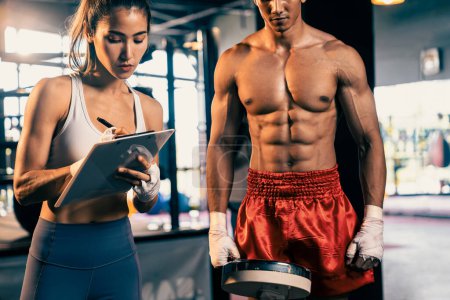 Photo for Muay Thai boxer step on weight scale for boxing class designation by weight measurement before boxing fight match. Dedicated athlete fitness and physical boxers body readiness. Impetus - Royalty Free Image