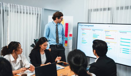 Photo for Project manager planning schedules for business task at meeting room, Gantt chart software show on TV screen. Multi ethnic diversity business people and modern business project management. Habiliment - Royalty Free Image