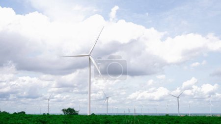 Foto de Manera progresiva de utilizar el viento como fuente de energía renovable para alimentar la forma moderna de vida por el parque eólico en campo verde o colina. Generador de molinos de viento eléctrico sin emisiones de CO2. - Imagen libre de derechos