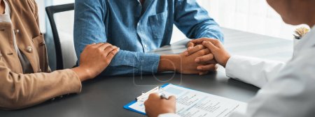 Photo for Doctor providing compassionate healthcare consultation while young couple patient holding hand, comfort each other after infertile report. Reproductive and medical fertility consulting. Neoteric - Royalty Free Image