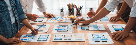 Photo for Panorama shot of front-end developer team brainstorming UI and UX designs for mobile app on paper wireframe interface. User interface development team planning for user-friendly UI design. Scrutinize - Royalty Free Image