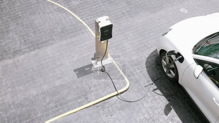 Téléchargez les photos : Innovation progressive borne de recharge urbaine électrique sur route avec batterie de véhicule électrique chargée d'énergie verte pour des raisons environnementales afin de réduire les émissions de CO2. - en image libre de droit