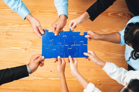 Photo for Top view multiethnic business people holding jigsaw pieces and merge them together as effective solution solving teamwork, shared vision and common goal combining diverse talent. Habiliment - Royalty Free Image