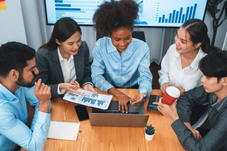 Photo for Multiracial analyst team use BI dashboard data to analyze financial report on meeting table. Group of diverse business people utilize data analysis by FIntech for success business marketing. Concord - Royalty Free Image