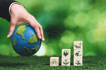 Téléchargez les photos : Main d'homme d'affaires tenant la Terre, symbolisant les entreprises vertes utilisant la technologie des biocarburants et la conservation de l'environnement pour une énergie durable et respectueuse de l'environnement pour un avenir propre. Modifier - en image libre de droit