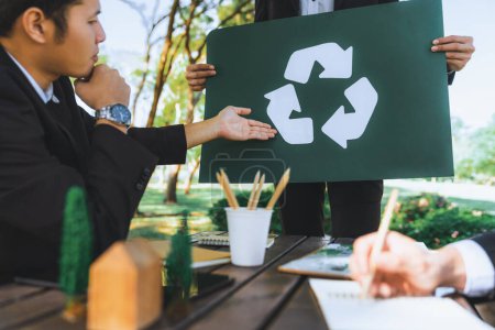 Téléchargez les photos : Groupe de gens d'affaires réunis au bureau extérieur dans la planification de la nature et de remue-méninges sur la stratégie de recyclage pour un environnement plus vert en réduisant et en réutilisant les déchets recyclables. Pneumatique - en image libre de droit