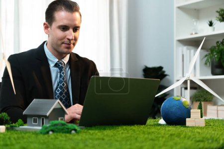 Photo for Businessman planning on his laptop for implementation of clean and sustainable energy to reduce CO2 emission in eco green company with for greener sustainable Earth. Quaint - Royalty Free Image