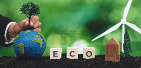 Foto de Empresario crecer árbol en globo de papel con símbolo de cubo ECO en suelo fértil. La regeneración forestal y la promoción de la conciencia natural del medio ambiente verde mediante el uso de turbinas eólicas y energía limpia. Alteración - Imagen libre de derechos