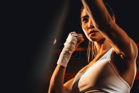 Téléchargez les photos : Entraînement de boxeuse asiatique Muya Thai, coup de poing enveloppé à la main au sac de coups de pied à la salle de gym. Mode de vie sain en sport et en conditionnement physique, Entraînement de force et d'endurance pour un match de boxe. Impulsion - en image libre de droit