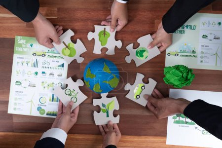 Top view cohesive group of business people holding eco icon jigsaw puzzle pieces around globe Earth as eco corporate responsibility for community and sustainable solution for greener Earth. Quaint