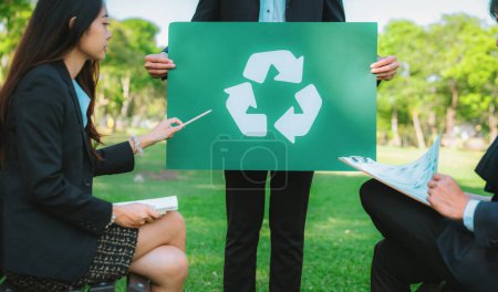Foto de Grupo de empresarios se reúnen en la oficina al aire libre en la planificación de la naturaleza y la lluvia de ideas sobre la estrategia de reciclaje para un medio ambiente más ecológico mediante la reducción y reutilización de residuos reciclables. Gyre. - Imagen libre de derechos