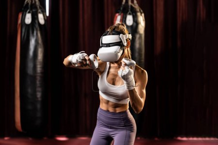 Téléchargez les photos : Entraînement de boxeuse avec VR ou réalité virtuelle, port casque VR avec technique d'entraînement de boxe immersive en utilisant contrôleur pour améliorer ses compétences en simulateur de boxe. Impulsion - en image libre de droit