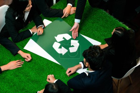Téléchargez les photos : Recycler icône sur la table de réunion dans le bureau avec les gens d'affaires qui planifient l'investissement éco-entreprise sur la gestion des déchets comme recyclage réduire le concept de réutilisation pour un écosystème propre. Charmante. - en image libre de droit