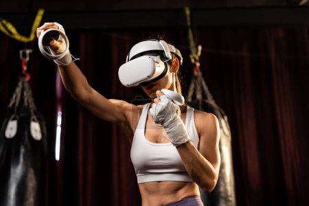 Foto de Entrenamiento de boxeadora femenina con realidad virtual o realidad virtual, con auriculares VR con técnica de entrenamiento de boxeo inmersivo utilizando controlador para mejorar su habilidad en simulador de boxeo. Impulso - Imagen libre de derechos
