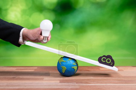 Photo for Sustainable idea in balance on weight scale of eco conservation vs CO2 symbol. Business hand holding lightbulb represent ESG idea toward green future as corporate responsibility on eco system. Alter - Royalty Free Image