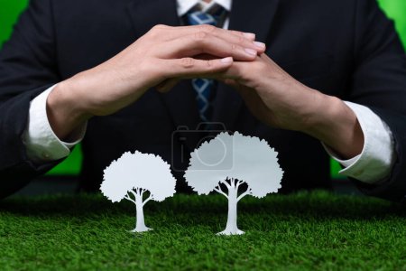Photo for Businessman holding tree icon symbolize eco-friendly business corporation committed to environmental friendly CSR practice and zero carbon emission. Corporate responsible for greener society. Gyre - Royalty Free Image