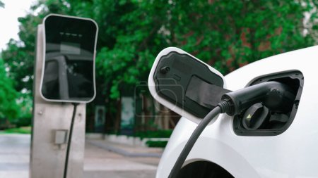 Photo for Progressive sustainability of energy concept by electric car parking and recharging next to home charging station. Electric vehicle driven by renewable energy for environmental preservation. - Royalty Free Image