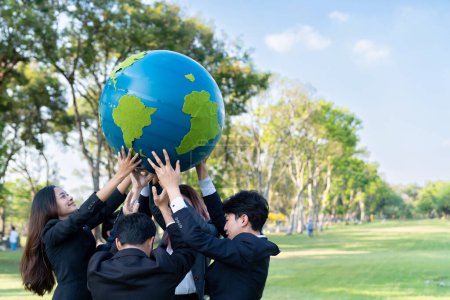 Foto de Concepto del Día de la Tierra con gran globo terráqueo sostenido por un grupo de empresarios asiáticos que promueven la conciencia ambiental para resolver el calentamiento global con sostenibilidad ambiental y principio ESG. Gyre. - Imagen libre de derechos