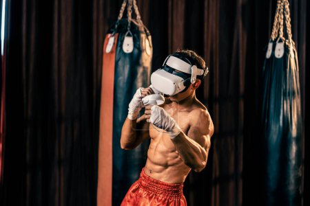 Photo for Boxer training utilizing VR technology or virtual reality, wearing VR headset with immersive boxing training technique using controller to enhance his skill in boxing simulator environment. Impetus - Royalty Free Image