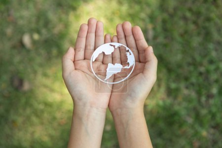 Foto de La vista superior de la mano que sostiene el icono del planeta Tierra simboliza el compromiso ecológico con la protección del medio ambiente y la emisión de carbono cero. Concepto del Día Mundial de la Tierra para promover la conciencia ecológica. Gyre. - Imagen libre de derechos