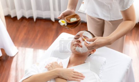 Photo for Serene ambiance of spa salon, woman customer indulges in rejuvenating with luxurious face cream massage with modern daylight. Facial skin treatment and beauty care concept. Quiescent - Royalty Free Image