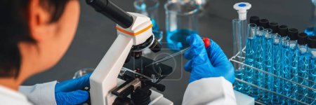 Foto de Los científicos llevan a cabo experimentos químicos utilizando microscopio en el laboratorio médico para desarrollar un nuevo fármaco vacunal o antibiótico. Laboratorio de biotecnología y concepto de investigación en medicina. Neotérico - Imagen libre de derechos