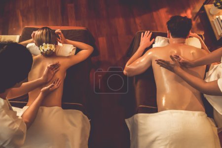 Foto de Top view pareja de clientes disfrutando de relajantes masajes de spa anti-estrés y mimos con belleza recreación de la piel de ocio en caliente iluminación de velas salón de ambiente spa en un resort de lujo u hotel. Silencioso. - Imagen libre de derechos